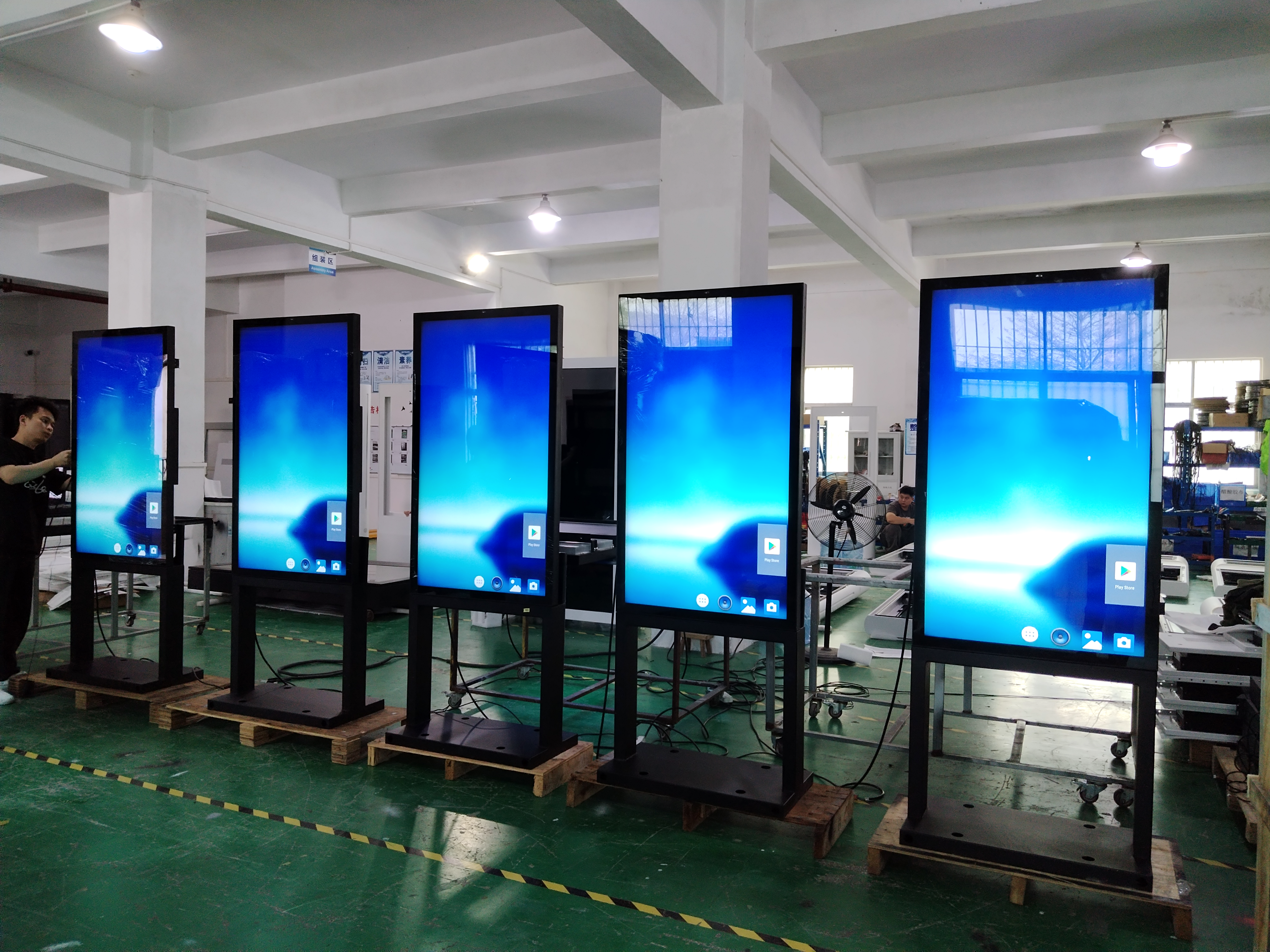 Display preparation area with display units and assembly staff; supplied photograph